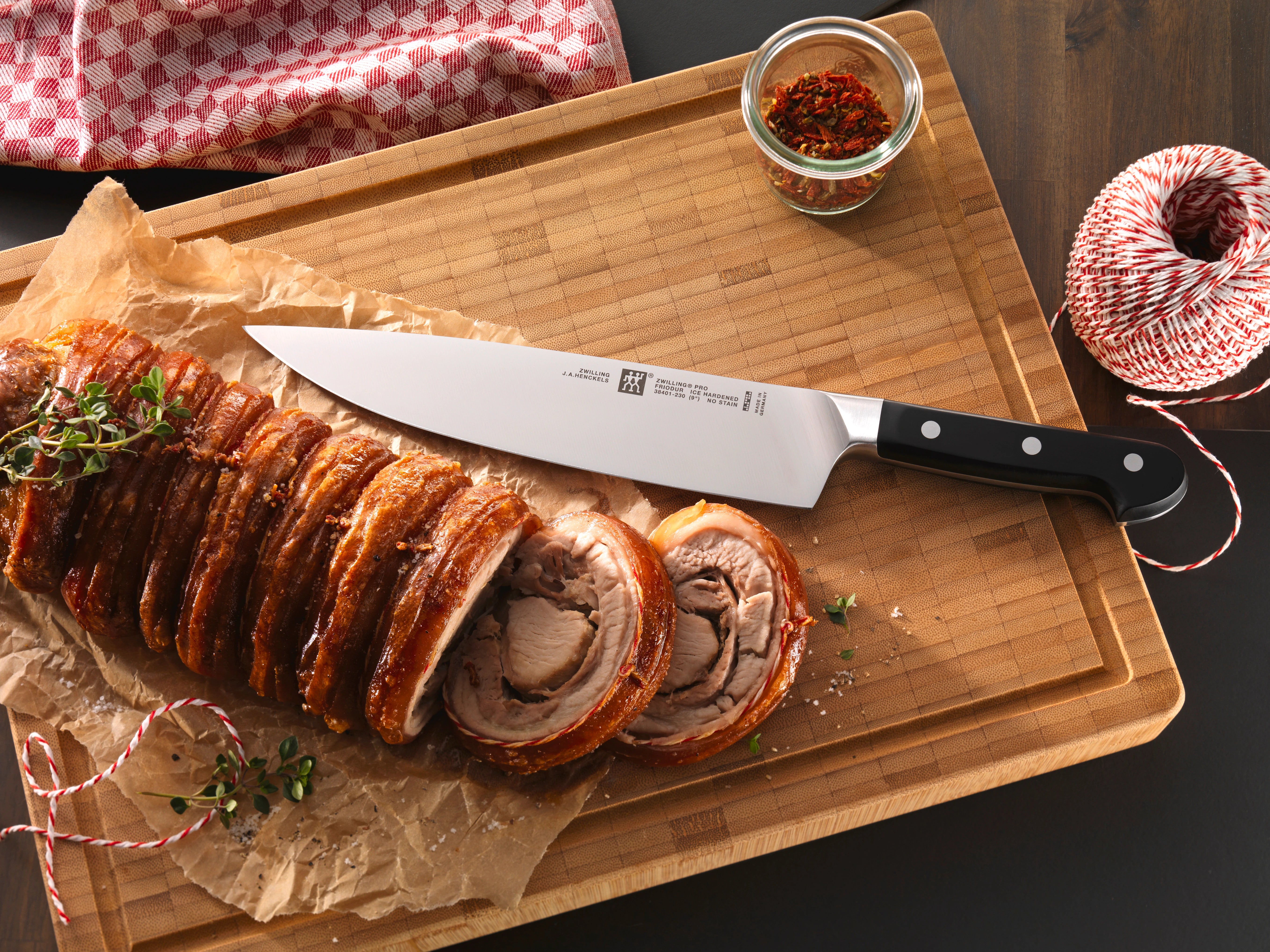 Zwilling pro chef knife on a chopping board with sliced food